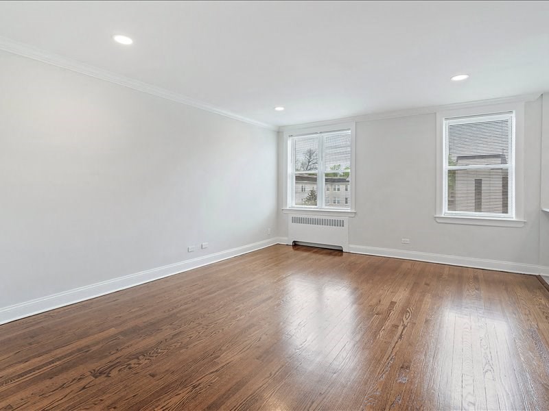 A room with wooden flooring and white walls.
