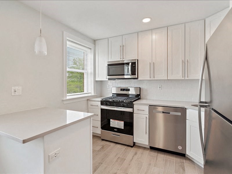A kitchen with white cabinets and stainless steel appliances.
