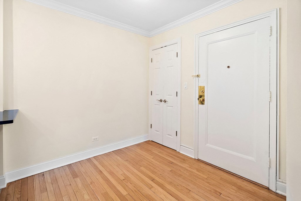 a bedroom with two doors and a wood floor