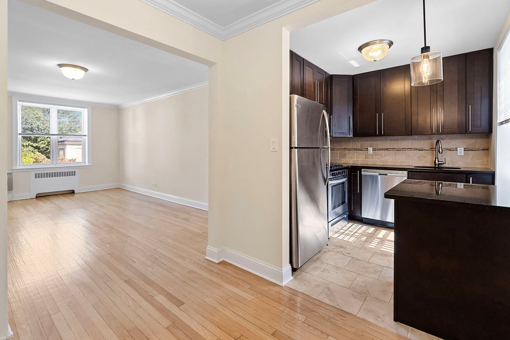 a renovated kitchen with stainless steel appliances and wooden flooring