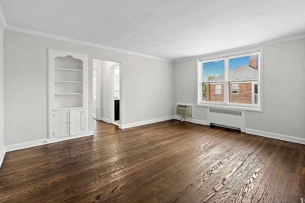 the living room of an empty house with wood floors and a window