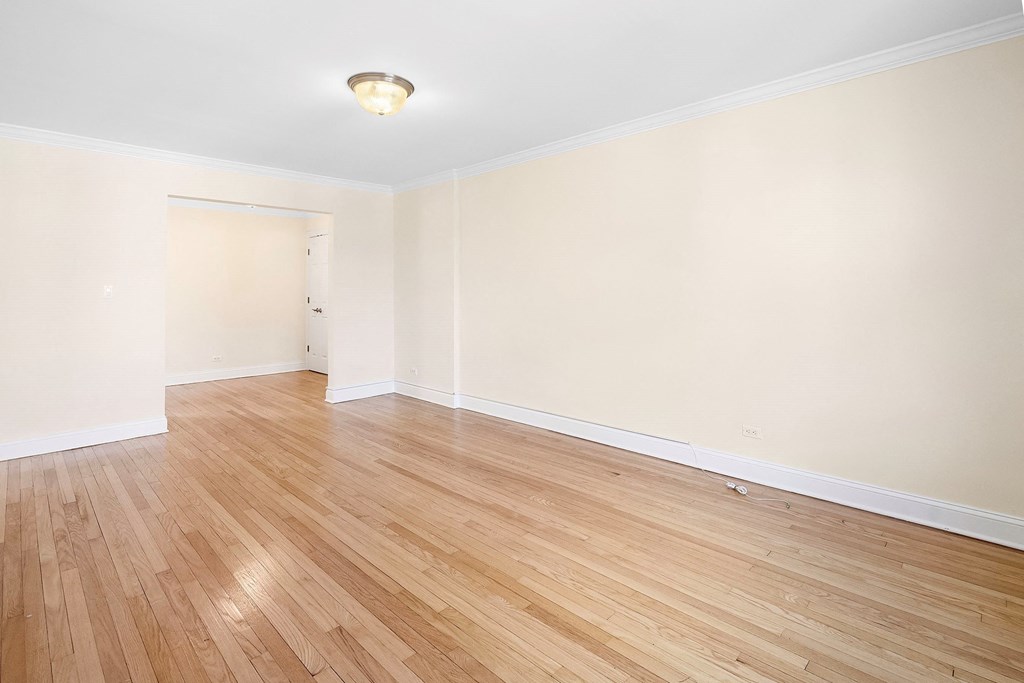an empty living room with wood floors and white walls
