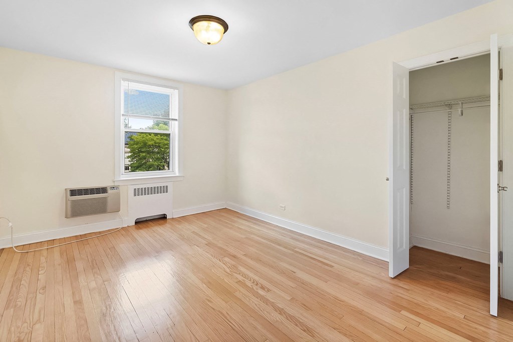 an empty room with wood flooring and a door to a closet