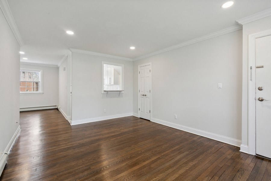 an empty living room with white walls and wood floors