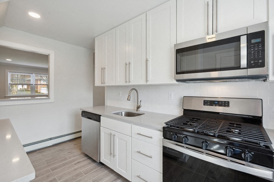 a kitchen with white cabinets and a stove and a microwave