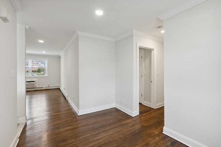an empty living room with white walls and wood floors