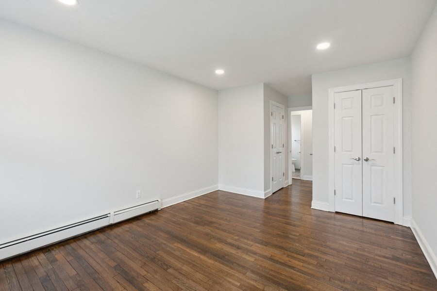 an empty living room with white walls and wood floors