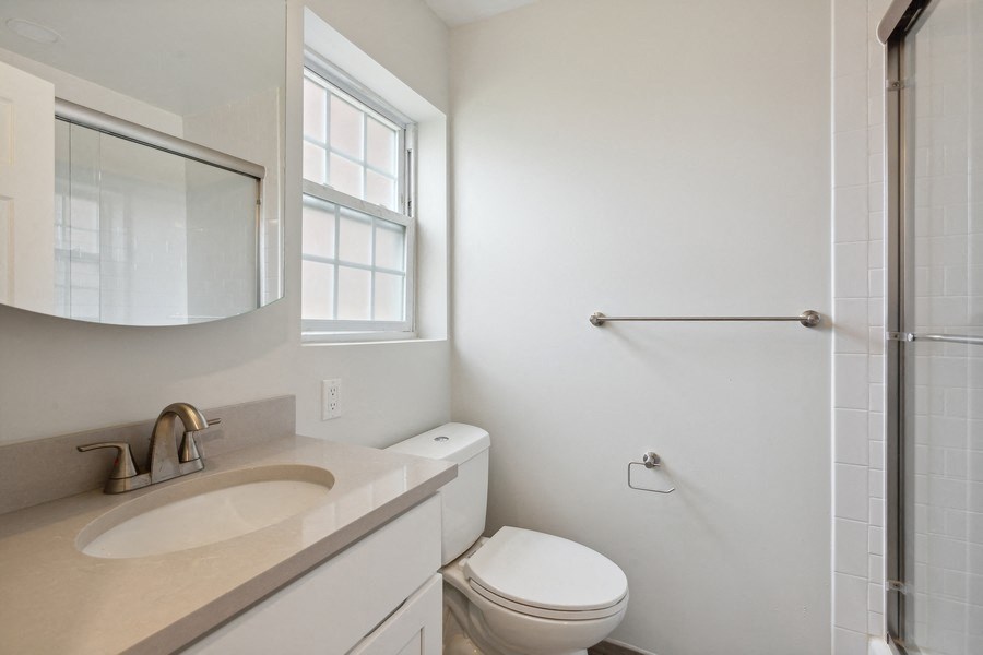 a bathroom with a toilet and a sink and a shower