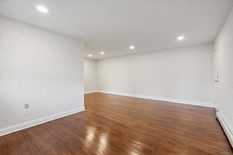 a living room with white walls and wood floors