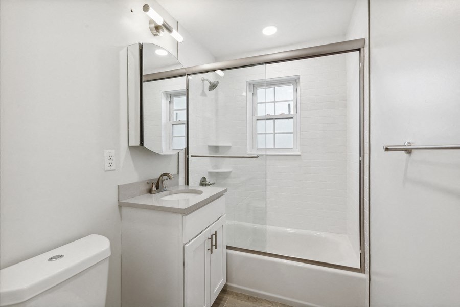 a white bathroom with a shower and a sink