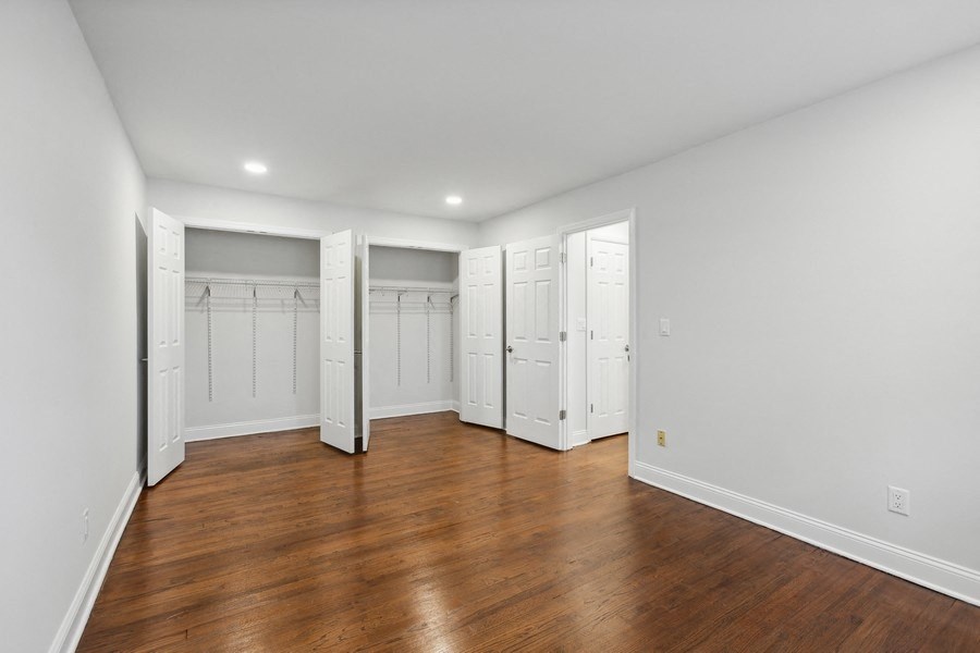 an empty room with white closets and wood floors