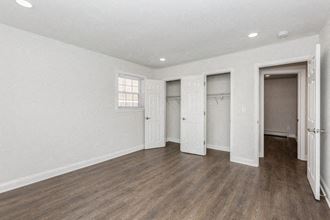 an empty living room with white walls and wood floors