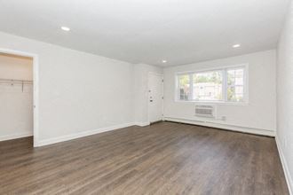an empty living room with white walls and a window