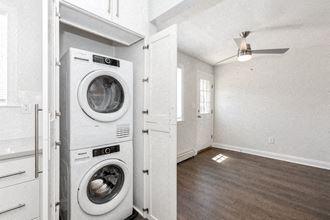 a white laundry room with a washer and a dryer