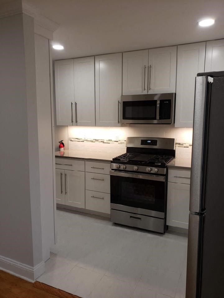 a white kitchen with a stove and a microwave