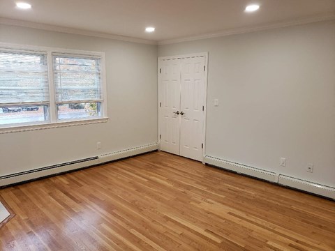 a living room with wood floors and a door and a window