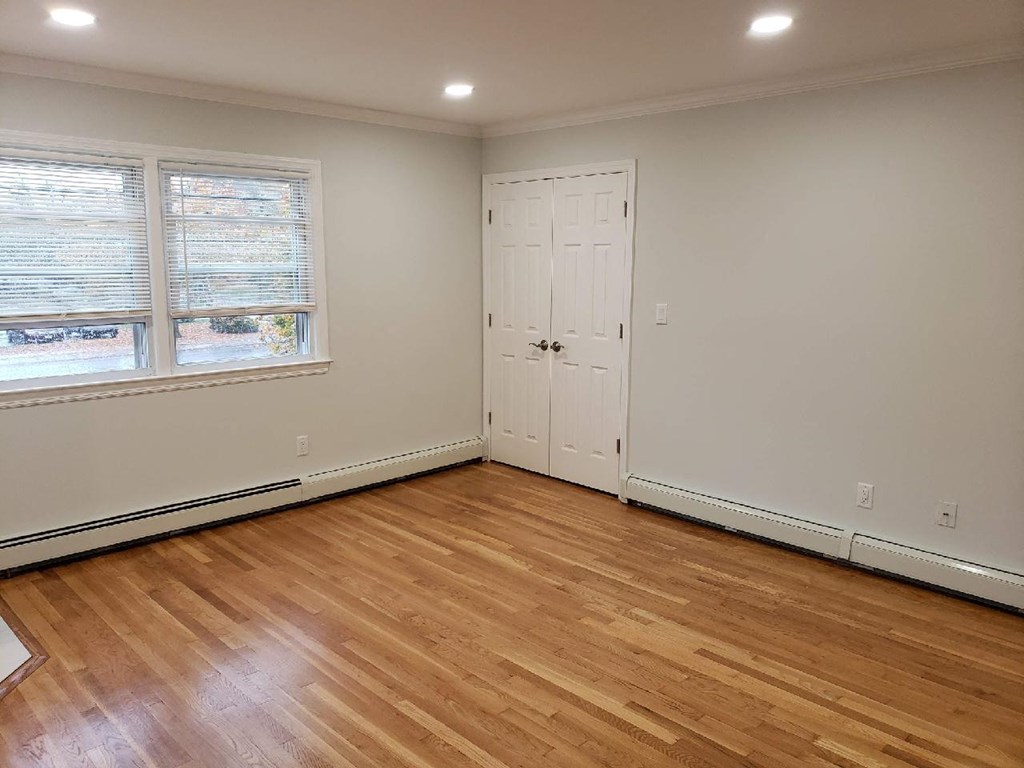 a living room with wood floors and a door and a window
