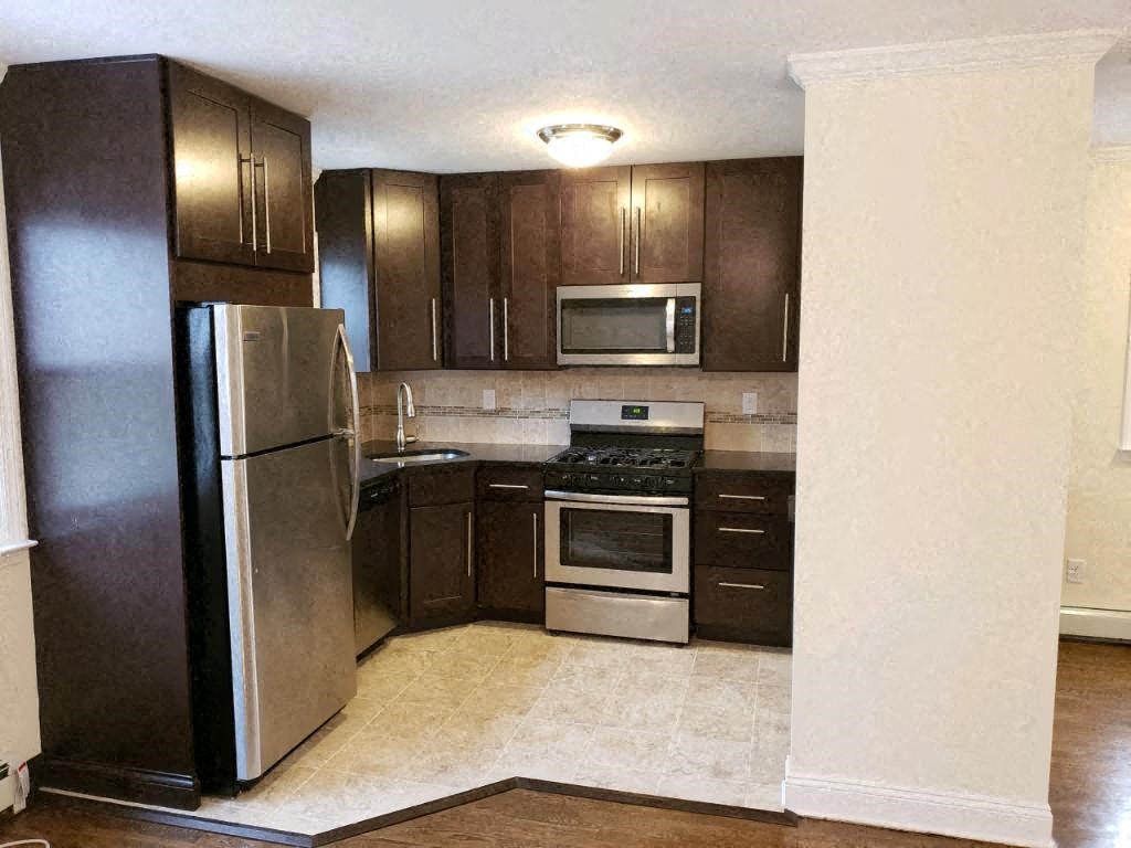 a kitchen with stainless steel appliances and wooden cabinets