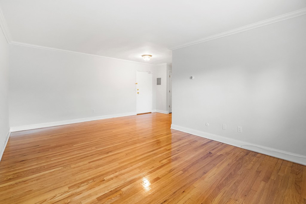 a living room with a hard wood floor and white walls