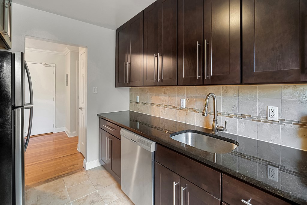 a kitchen with wooden cabinets and a sink and a refrigerator