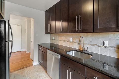 a kitchen with wooden cabinets and a sink and a refrigerator