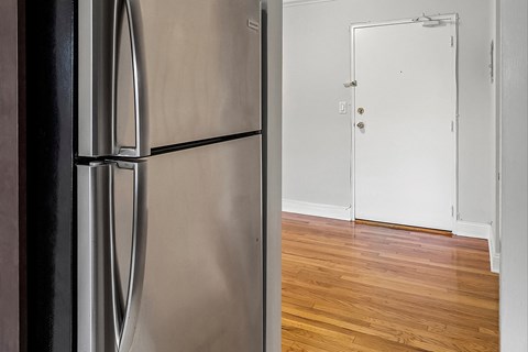 a kitchen with a stainless steel refrigerator and a white door