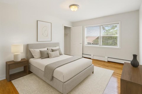 A bedroom with a large bed and a window overlooking a roof.