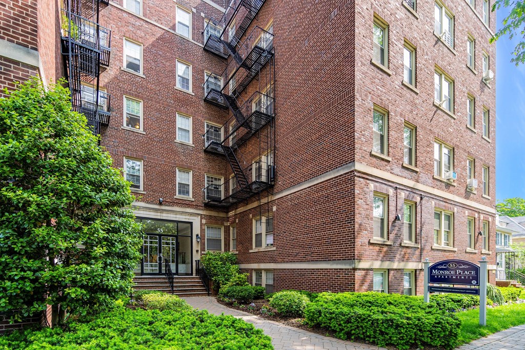 a brick apartment building with a sidewalk in front of it