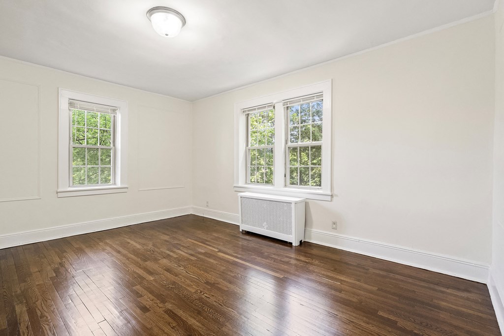 an empty living room with wood floors and white walls