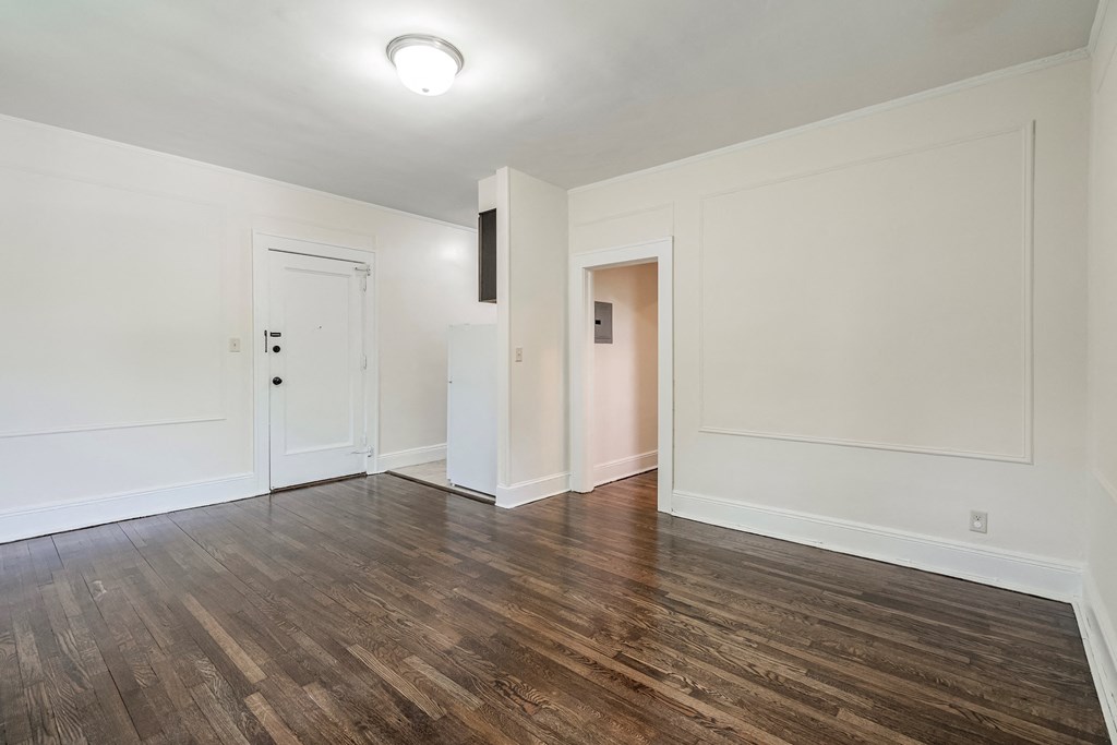 an empty living room with white walls and wood flooring
