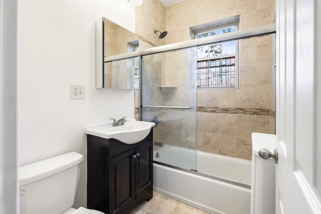 a bathroom with a shower and a sink and a toilet