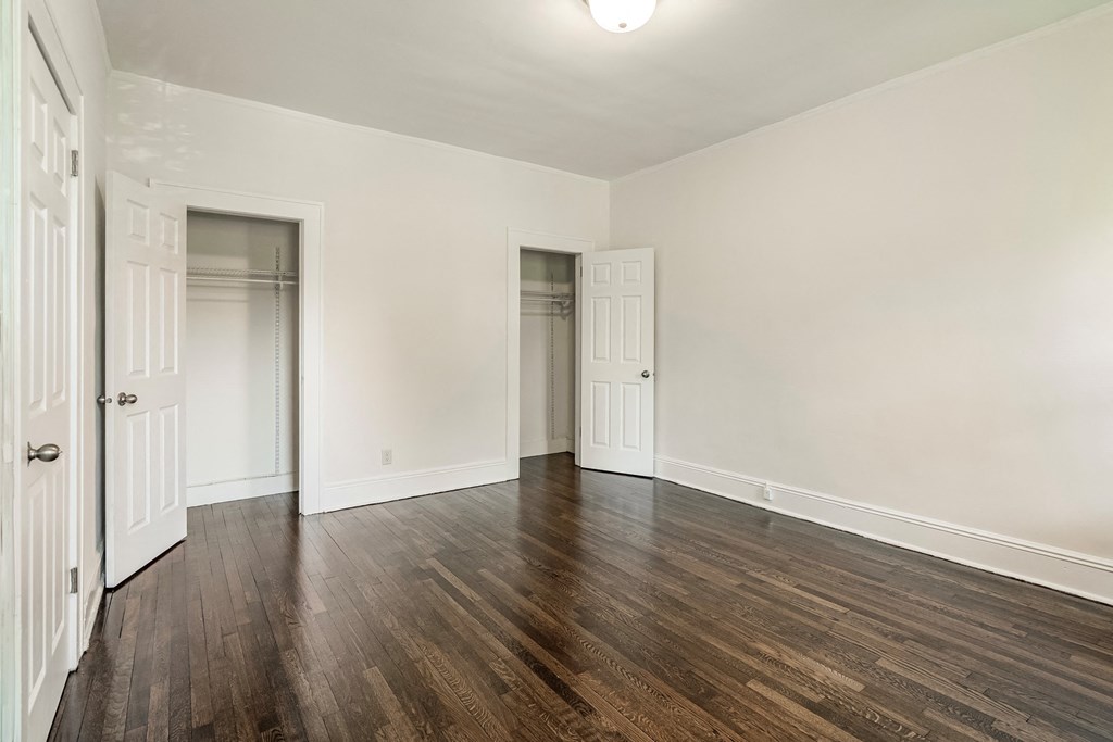 an empty living room with wood floors and white walls