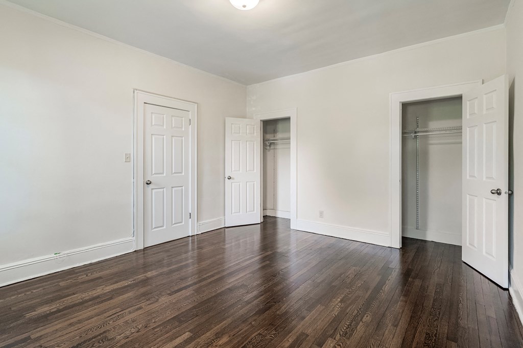 an empty living room with white walls and wood flooring