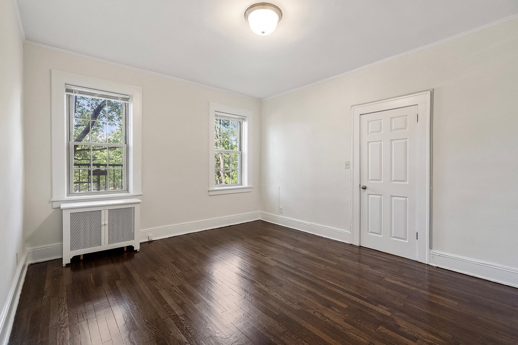 an empty living room with white walls and wood floors