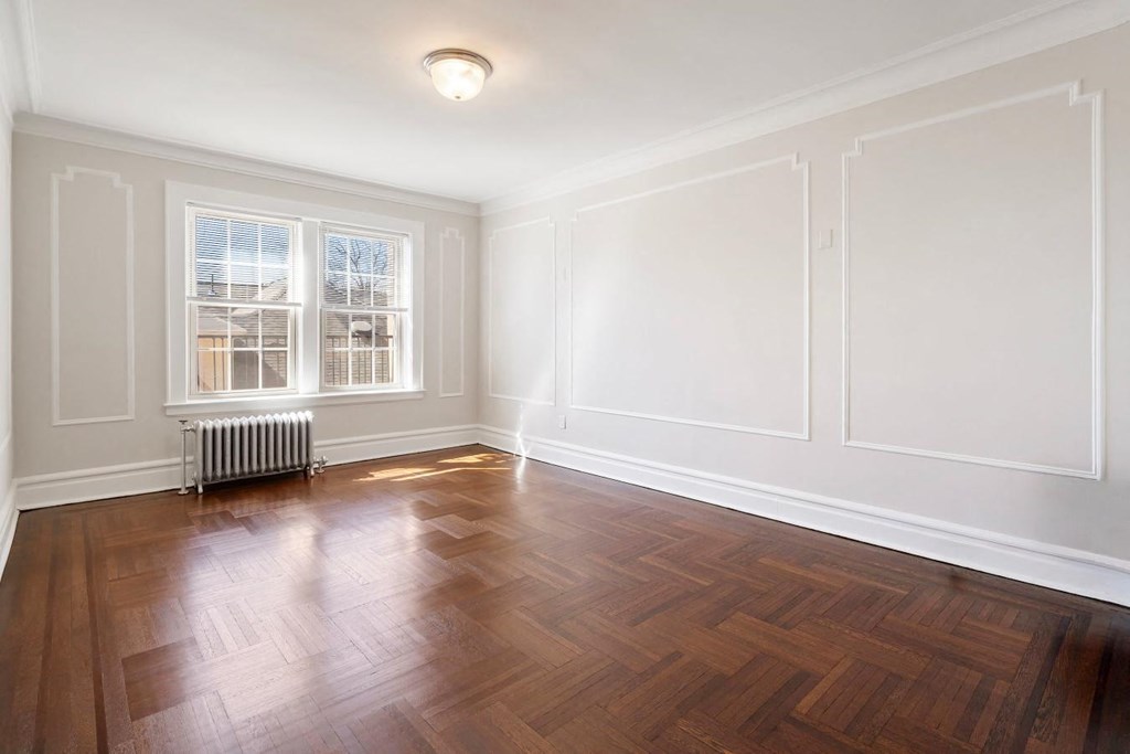 an empty living room with wood floors and white walls