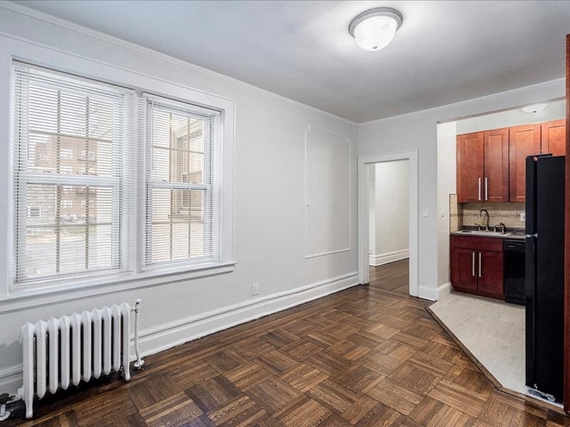 A room with a wooden floor and a white radiator.