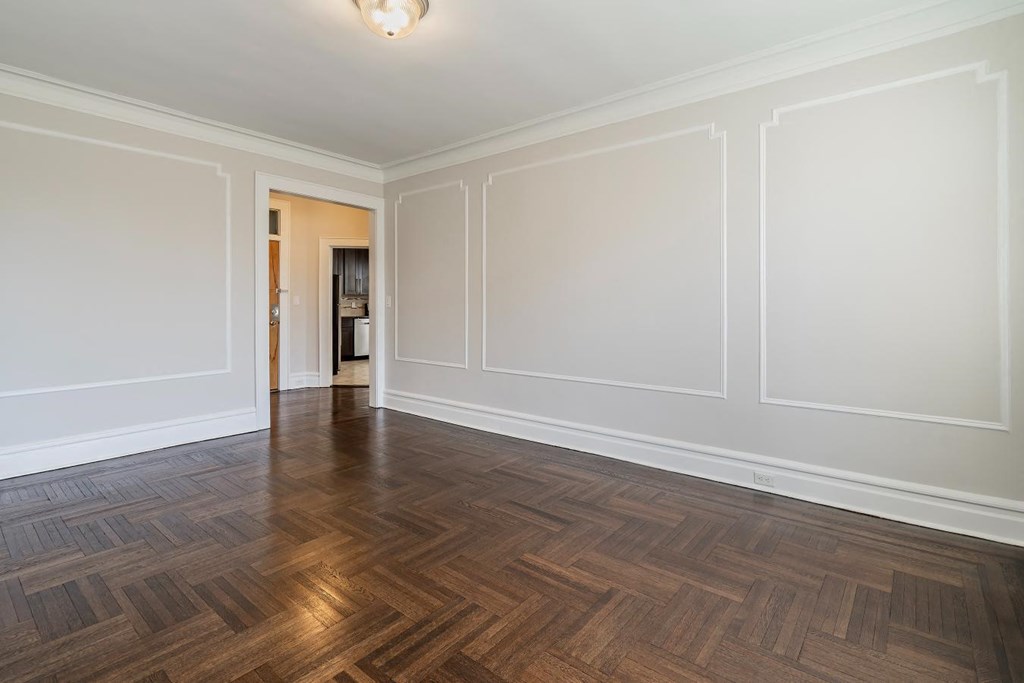 an empty living room with white walls and wood flooring