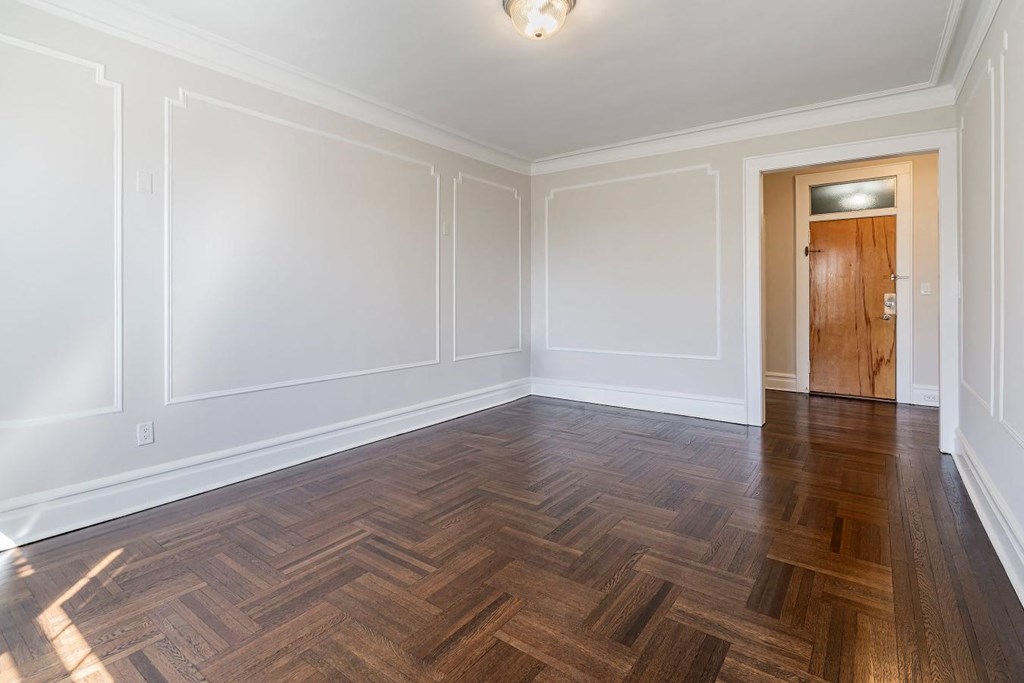 a living room with wood flooring and white walls