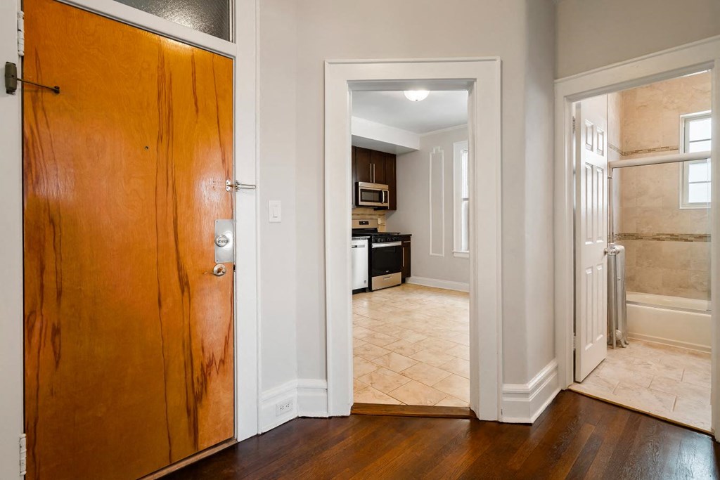 a wooden door leading into a kitchen and a living room