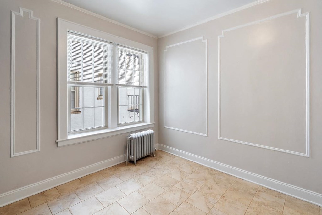 a living room with a large window and tiled floors