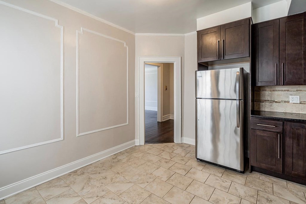 a kitchen with a stainless steel refrigerator and wooden cabinets