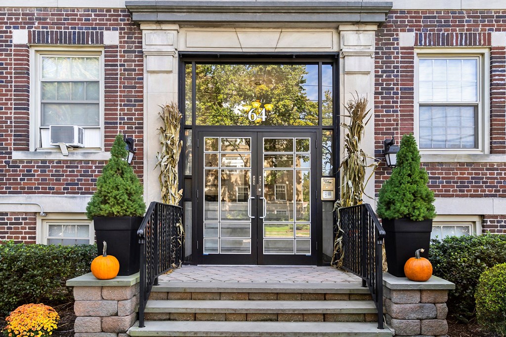 the front door of a house with pumpkins on the steps