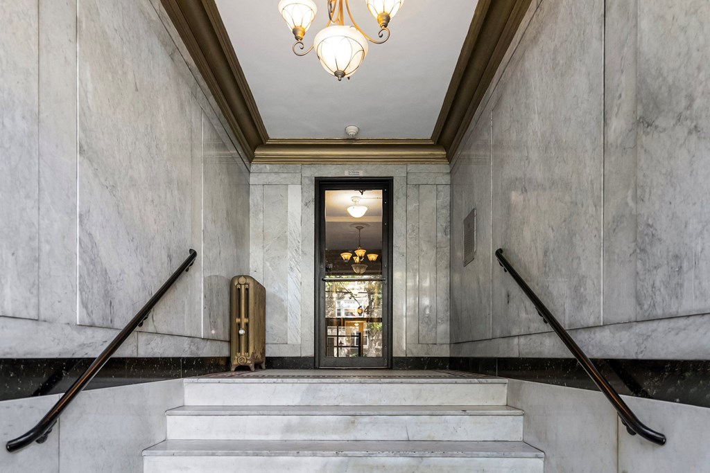 a lobby with stairs and a door and a chandelier