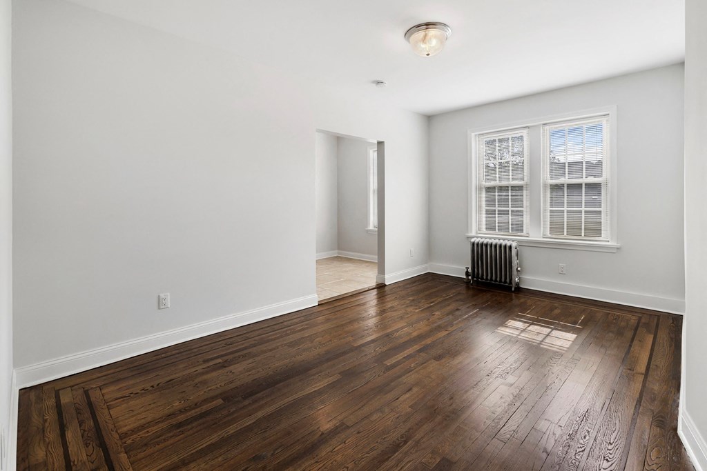 a living room with hardwood floors and a window