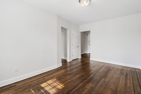 a living room with hardwood floors and white walls