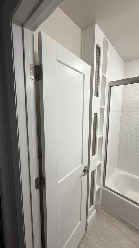 A white door is open to a bathroom.