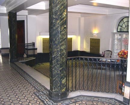 the lobby of a building with columns and a balcony