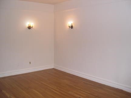 a empty room with white walls and wooden floors