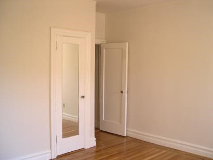 a room with two doors and a mirror in it