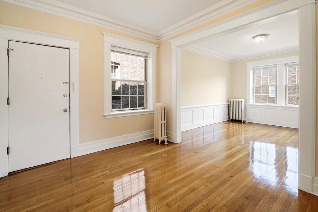an empty living room with wood floors and a white door